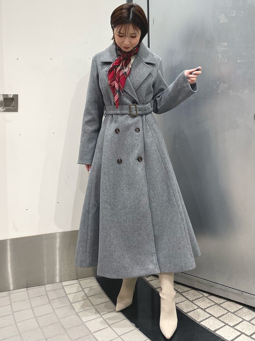 ホワイト系のブーツ、ブラック系のハンドバッグ、グレー系のその他アウターを着用したレディースの冬コーディネートの2枚目の写真