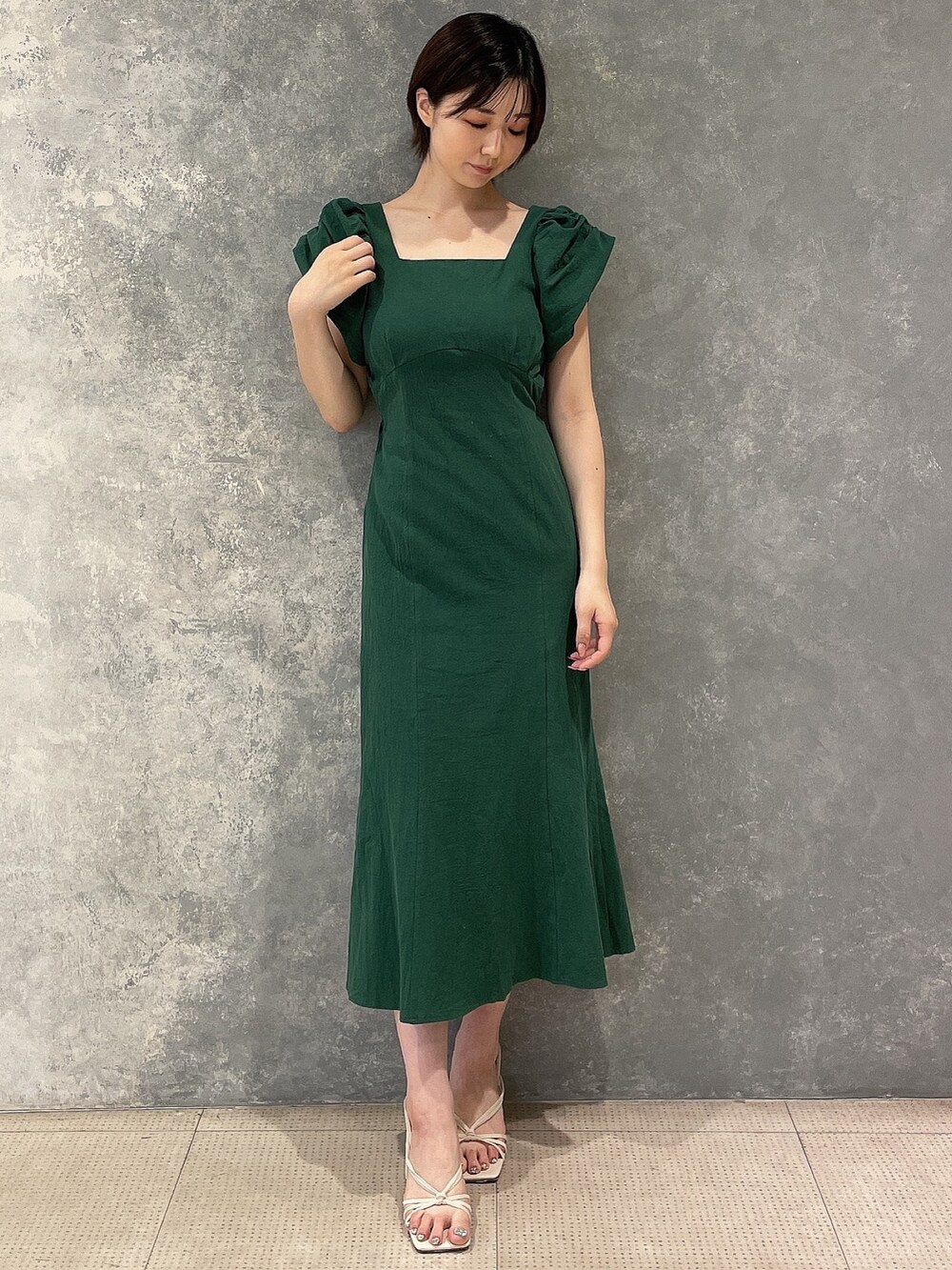 ホワイト系のサンダル、グリーン系のワンピースを着用したレディースの夏コーディネートの2枚目の写真