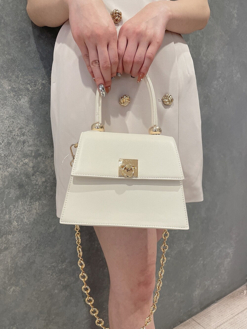 ホワイト系のワンピース、ホワイト系のハンドバッグ、ホワイト系のサンダルを着用したレディースの春コーディネートの8枚目の写真