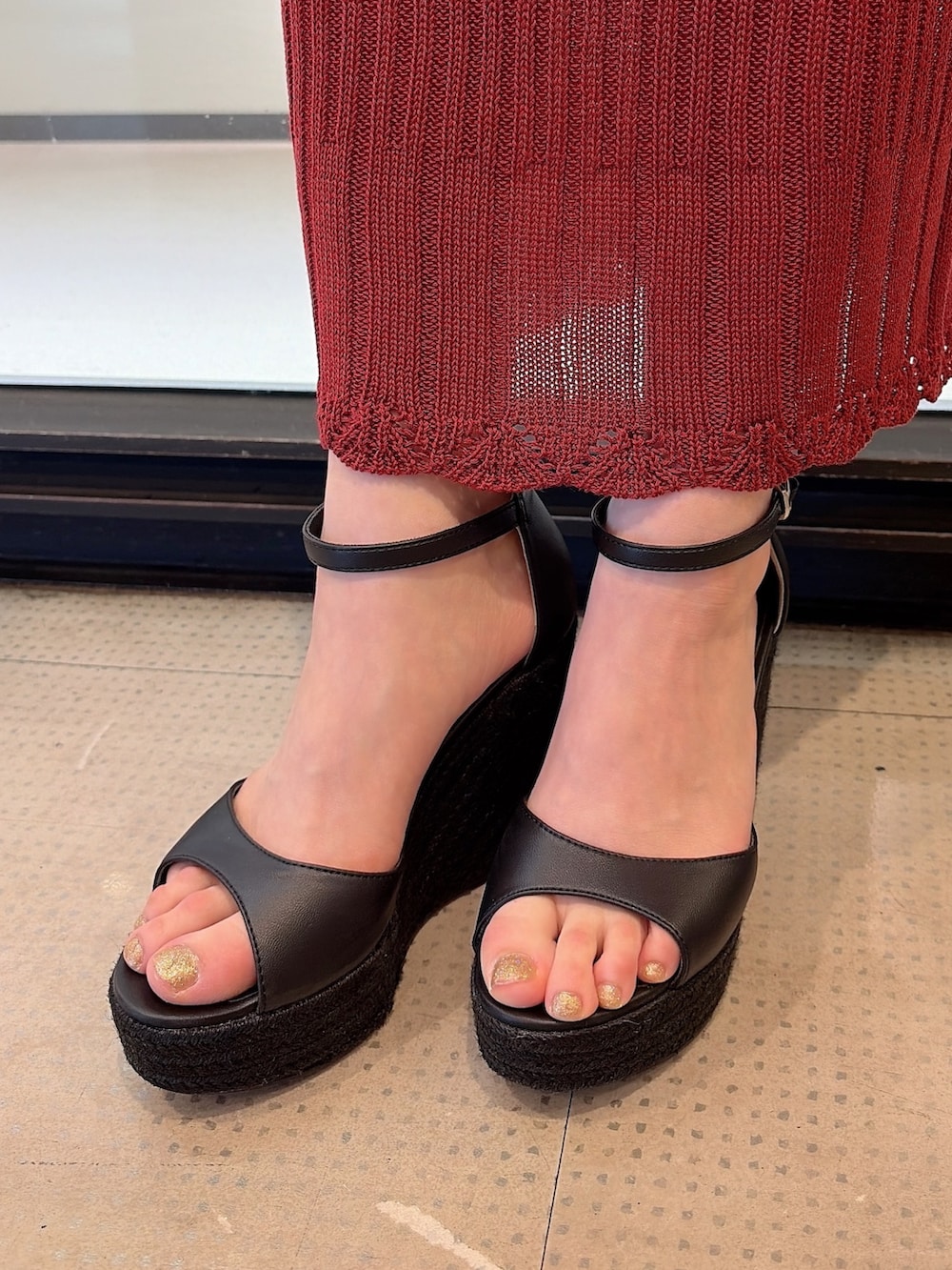 ブラウン系のハンドバッグ、ブラック系のサンダル、ブラウン系のワンピースを着用したレディースの夏コーディネートの7枚目の写真