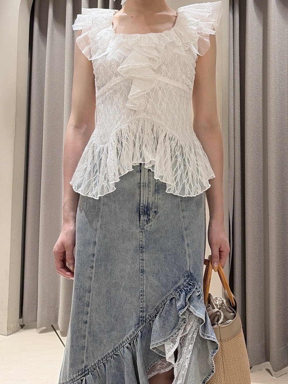 ホワイト系のシャツ/ブラウス、ブルー系のデニムスカート、ベージュ系のハンドバッグを着用したレディースの夏コーディネートの6枚目の写真