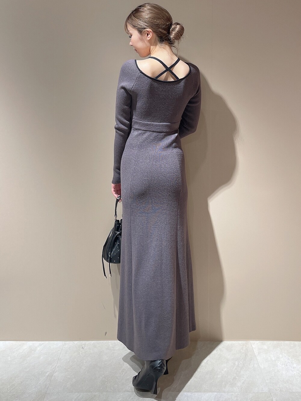 ブラック系のライダースジャケット、グレー系のワンピース、ブラック系のハンドバッグを着用したレディースの秋コーディネートの6枚目の写真