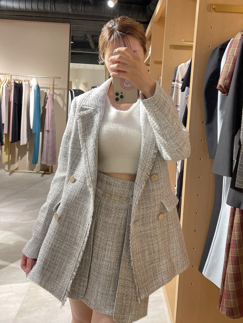 グレー系のテーラードジャケット、グレー系のスカート、ホワイト系のニット/セーターを着用したレディースの秋コーディネートの7枚目の写真