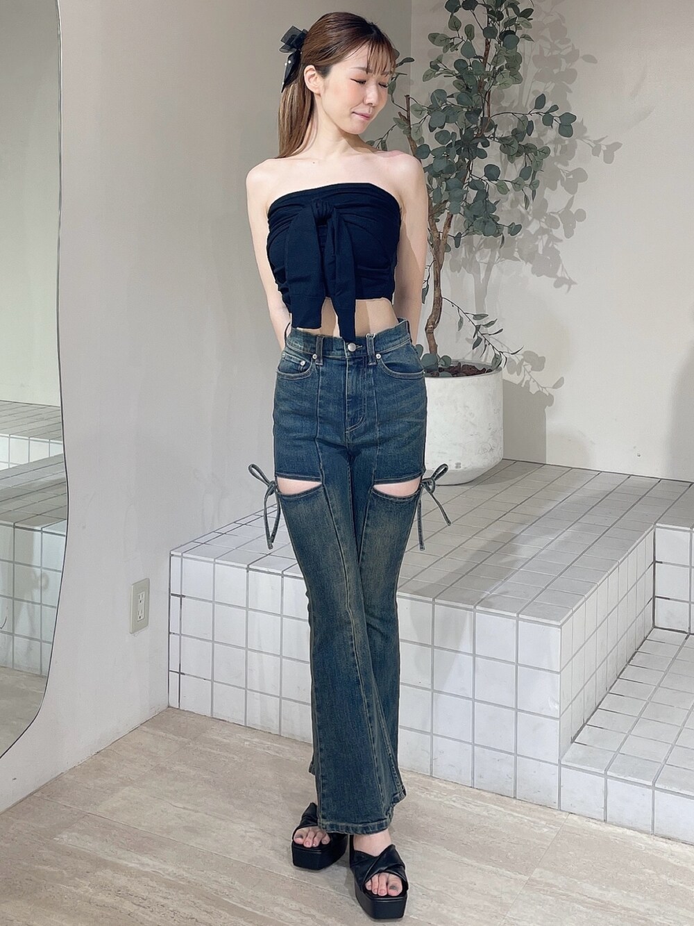 ブラック系のキャミソール、ブルー系のデニムパンツ、ブラック系のサンダルを着用したレディースの夏コーディネートの2枚目の写真