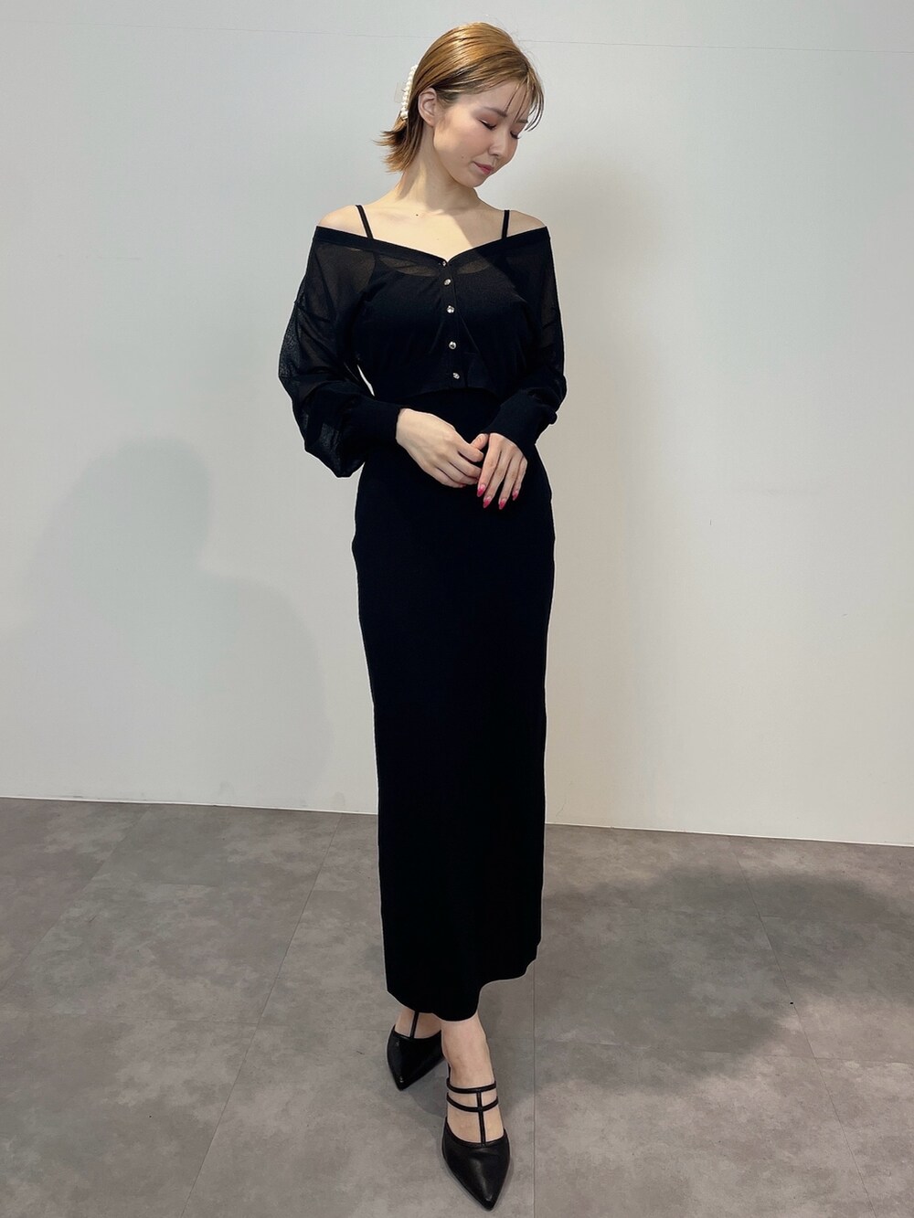 ブラック系のワンピース、ブラック系のパンプスを着用したレディースの冬コーディネートの2枚目の写真