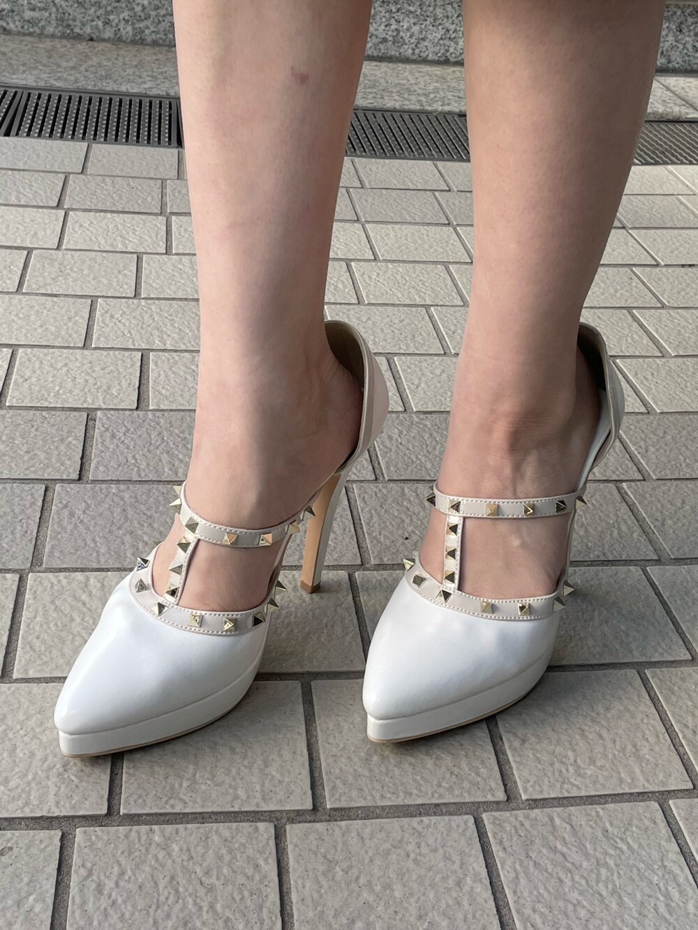 ホワイト系のパンプス、ホワイト系のスカート、ブラック系のニット/セーターを着用したレディースの冬コーディネートの9枚目の写真