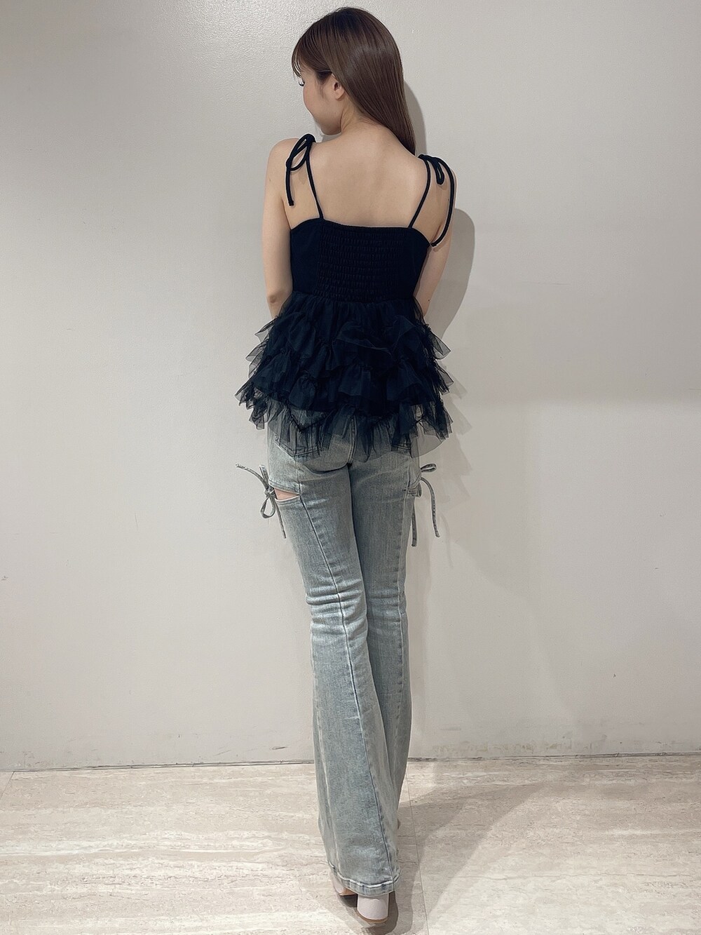 ブラック系のキャミソール、ブルー系のデニムパンツ、ベージュ系のサンダルを着用したレディースの夏コーディネートの4枚目の写真