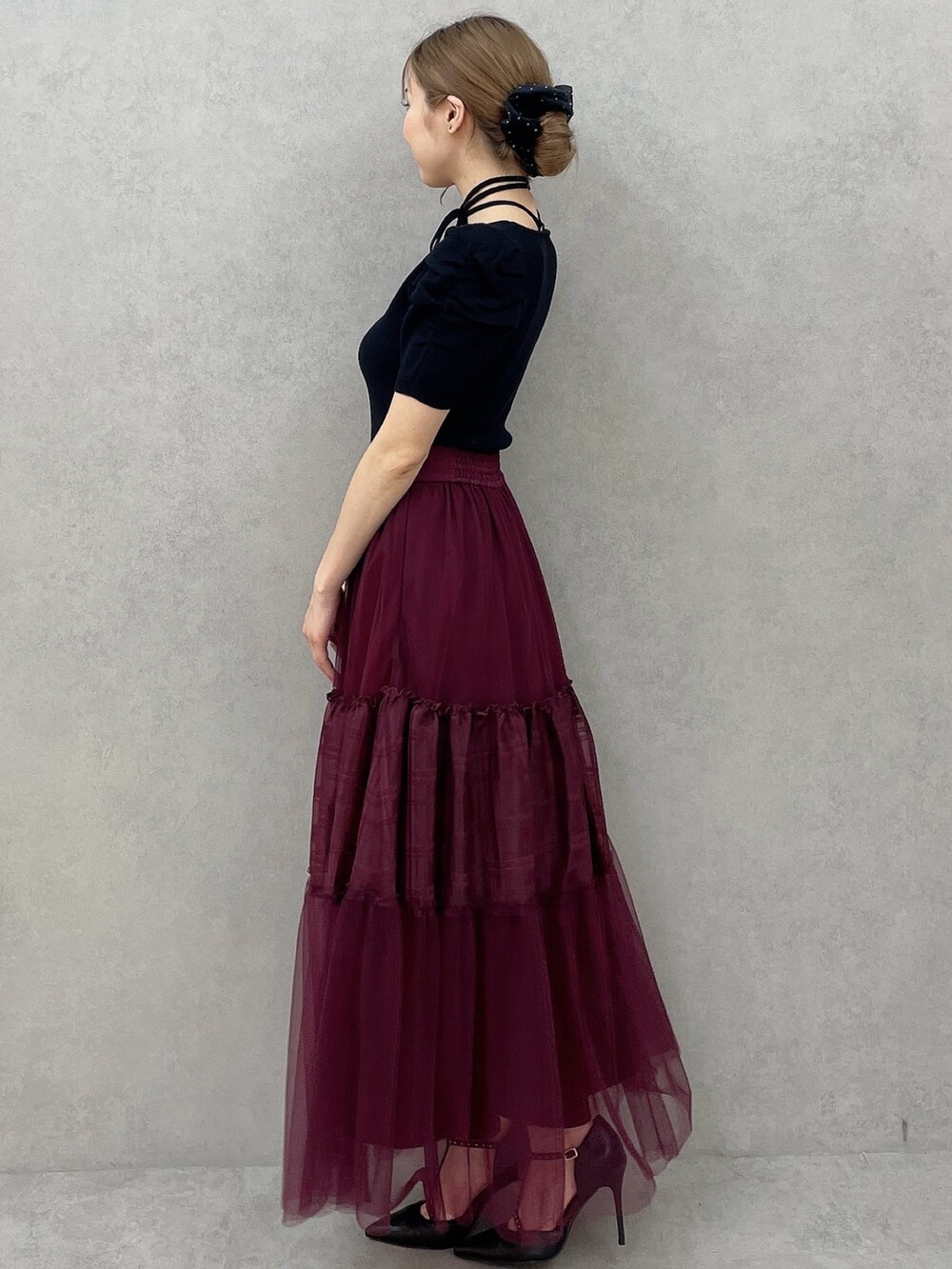 ブラック系のニット/セーター、レッド系のスカート、ブラック系のパンプスを着用したレディースの夏コーディネートの3枚目の写真