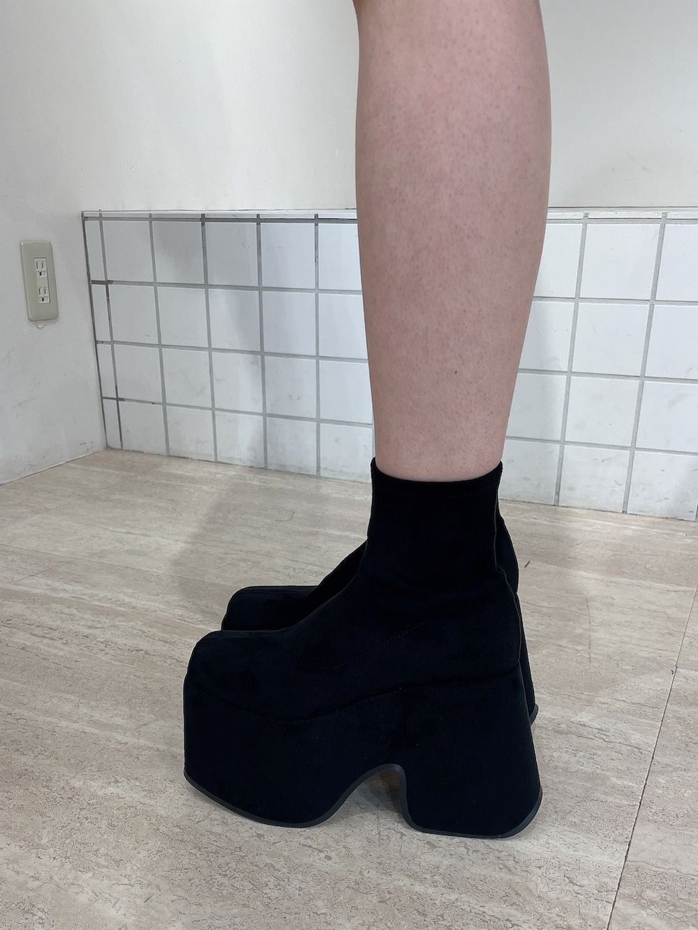 ブラック系のダウンジャケット/コート、ブラック系のキャミソール、ブルー系のデニムパンツを着用したレディースの秋コーディネートの10枚目の写真
