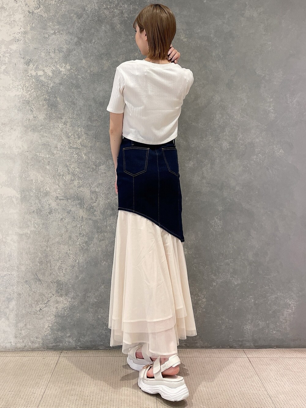 ホワイト系のカーディガン/ボレロ、ブルー系のスカート、ホワイト系のサンダルを着用したレディースの春コーディネートの3枚目の写真