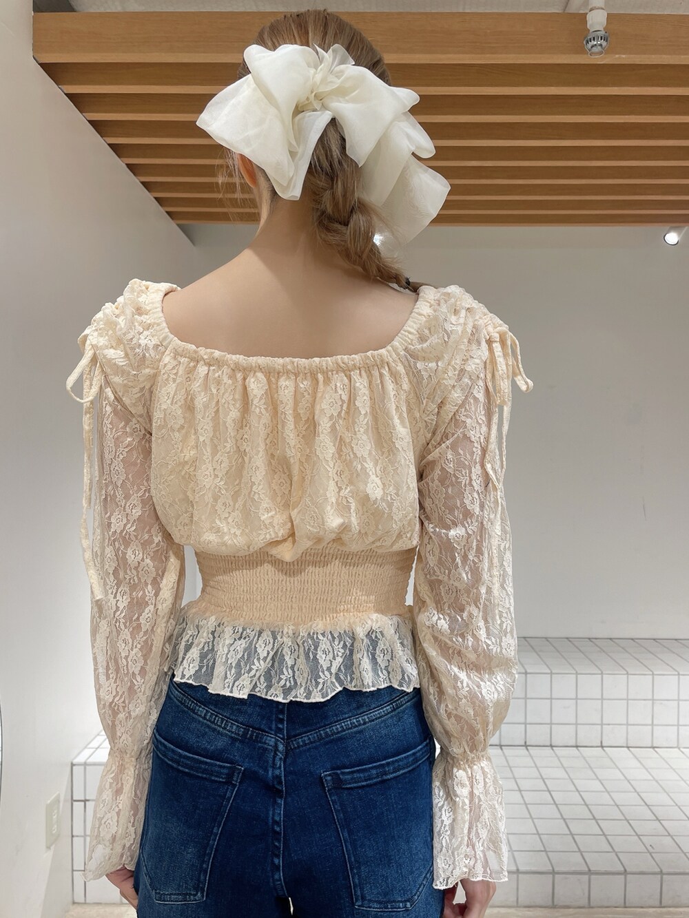 オレンジ系のシャツ/ブラウス、ブルー系のデニムパンツ、ホワイト系のブーツを着用したレディースの春コーディネートの6枚目の写真