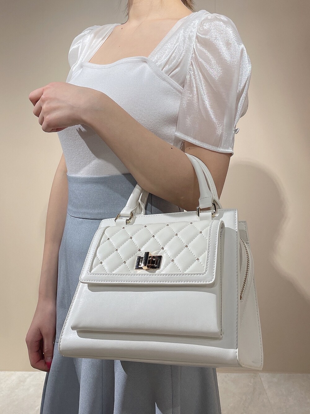 ホワイト系のニット/セーター、ブルー系のスカートを着用したレディースの春コーディネートの8枚目の写真