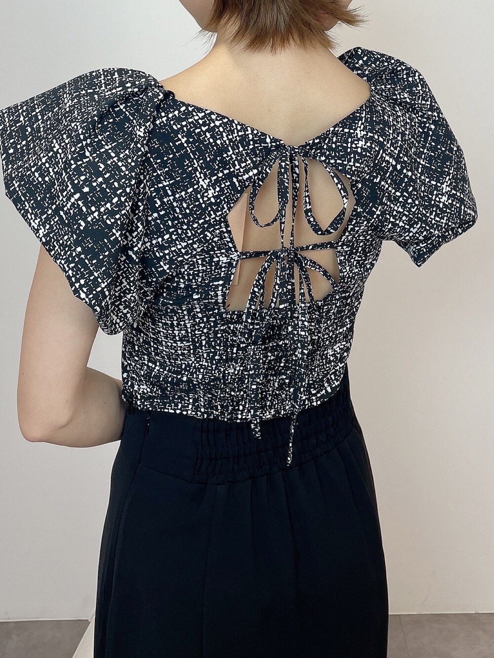 ブラック系のシャツ/ブラウス、ホワイト系のハンドバッグ、ブラック系のパンプスを着用したレディースの春コーディネートの8枚目の写真