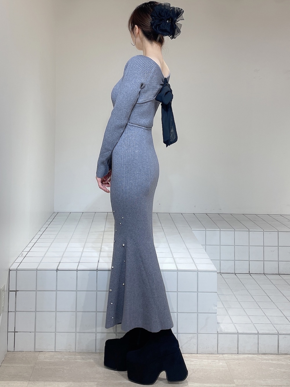 グレー系のワンピース、ブラック系のブーツ、ブラック系のバレッタ/ヘアクリップを着用したレディースの冬コーディネートの5枚目の写真