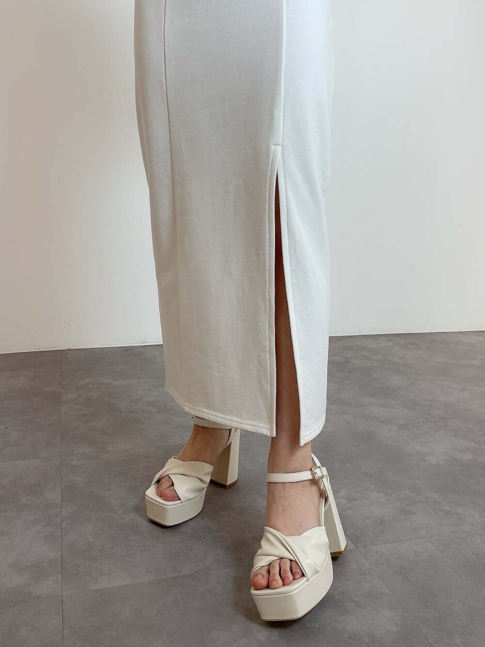 ホワイト系のワンピース、ホワイト系のサンダルを着用したレディースの春コーディネートの7枚目の写真