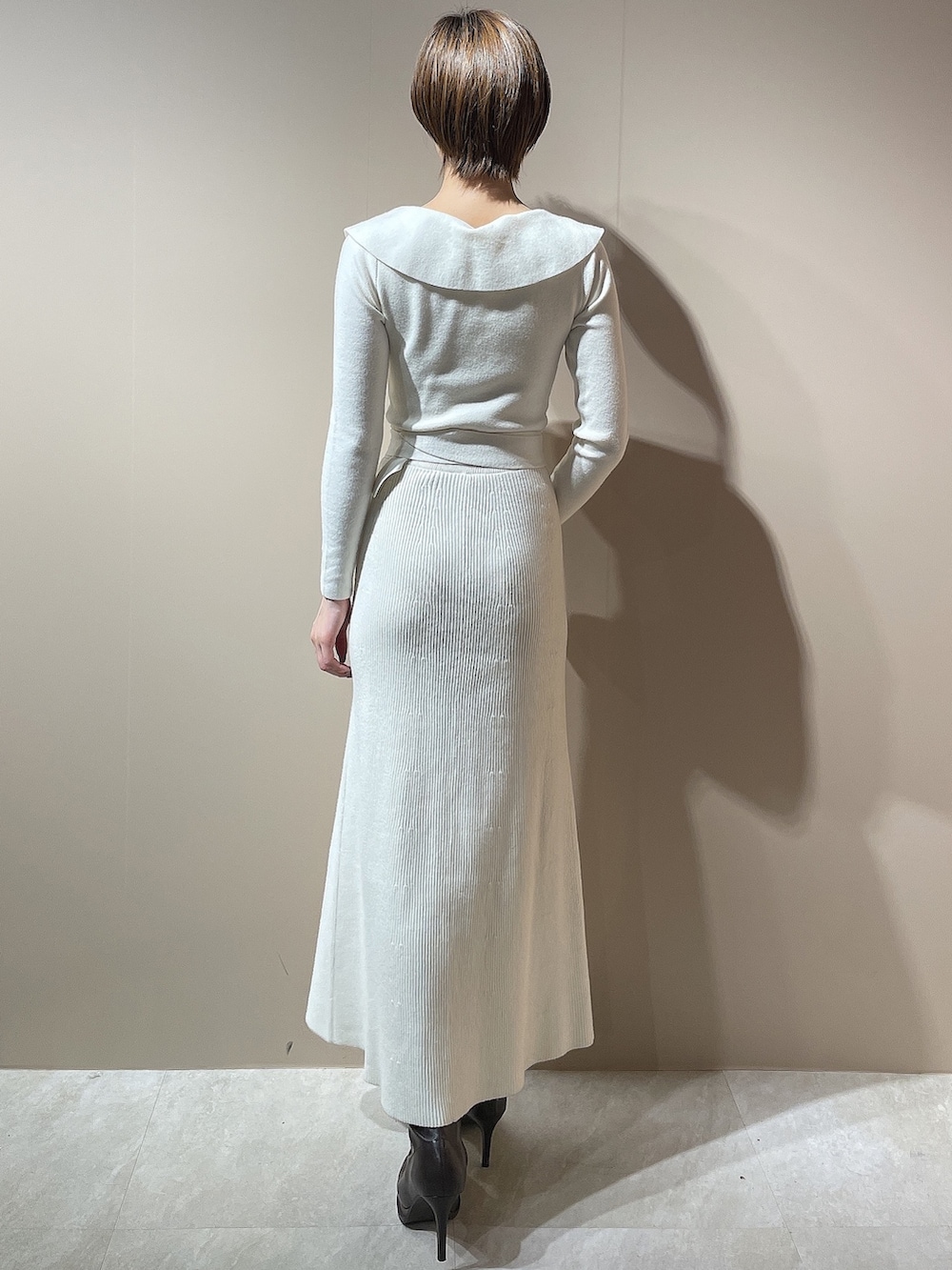 ホワイト系のダウンジャケット/コート、ホワイト系のワンピース、ブラウン系のブーツを着用したレディースの秋コーディネートの8枚目の写真