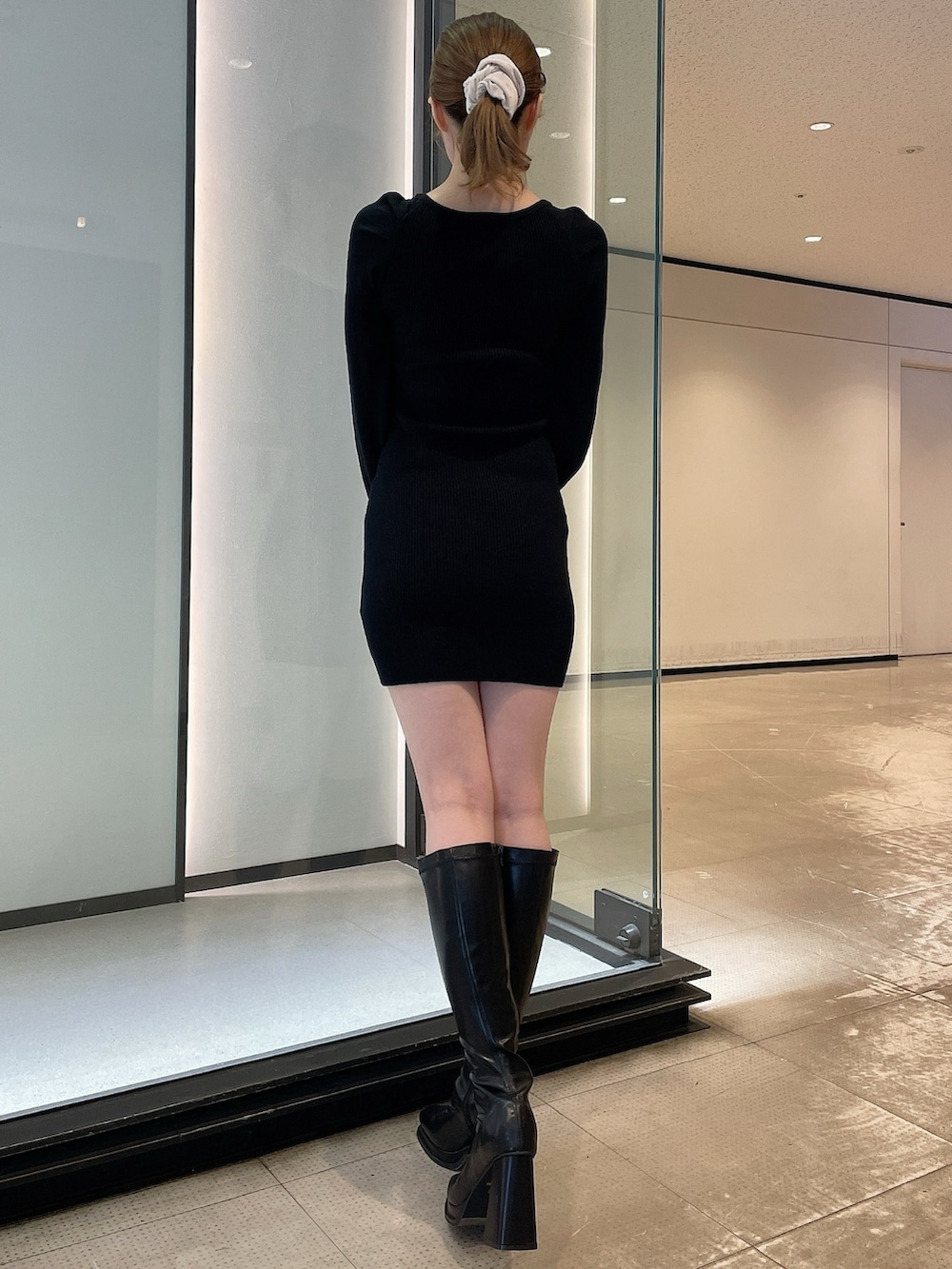 ホワイト系のその他アウター、ブラック系のワンピース、ブラック系のブーツを着用したレディースの冬コーディネートの6枚目の写真