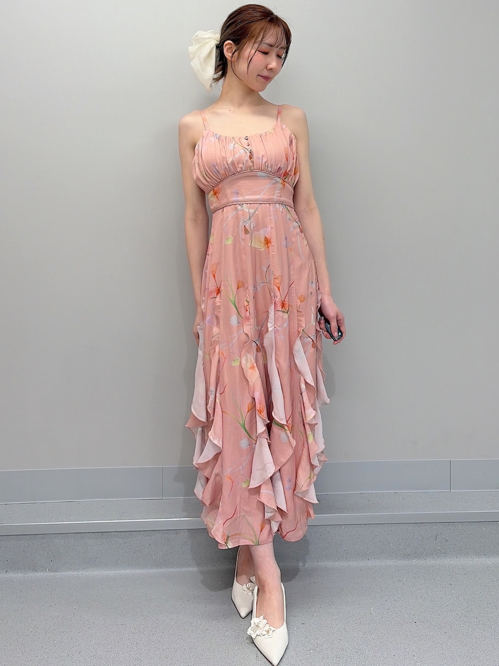 ホワイト系のトレンチコート、ピンク系のショルダーバッグ、オレンジ系のワンピースを着用したレディースの冬コーディネートの7枚目の写真