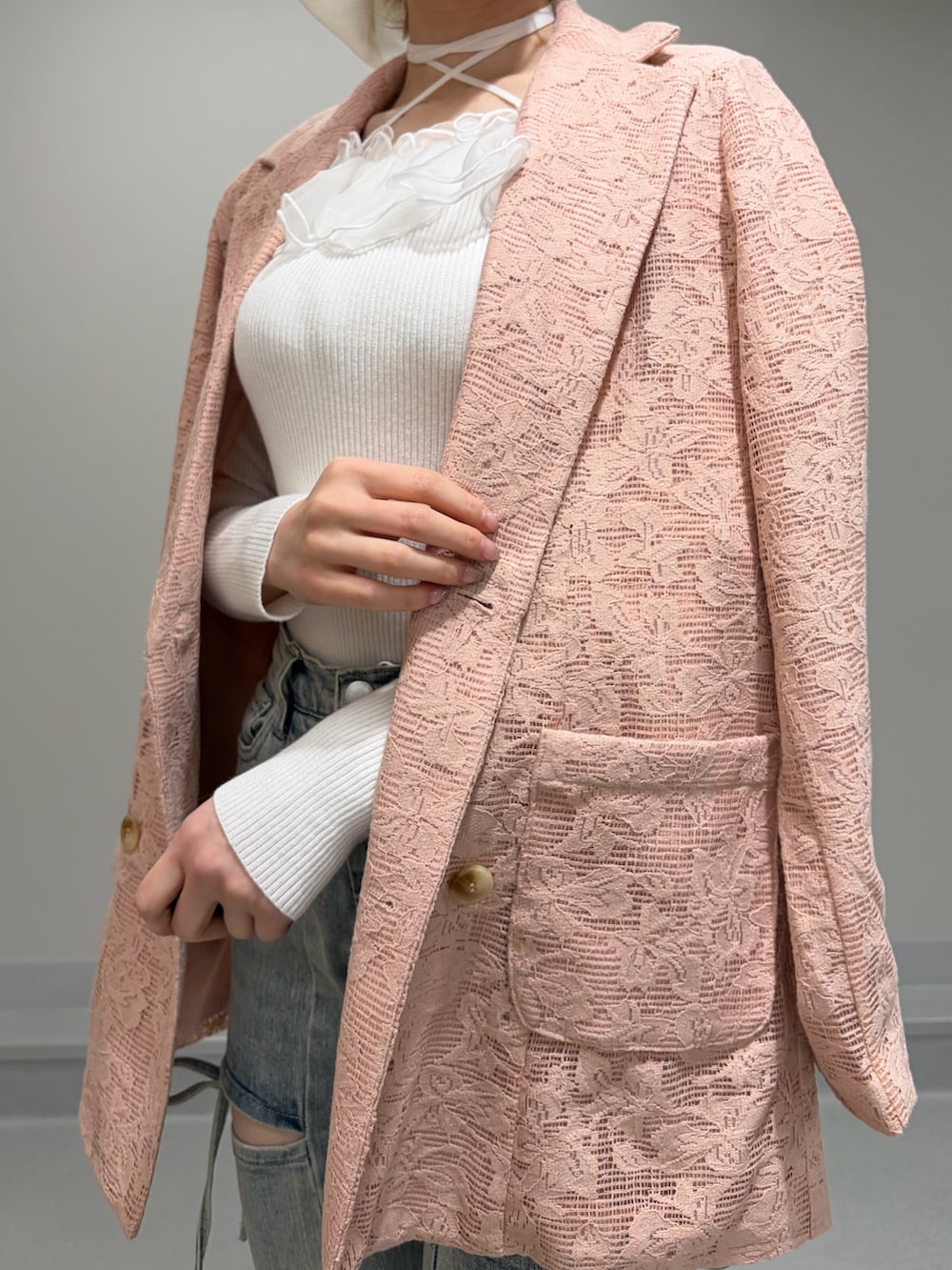 ピンク系のテーラードジャケット、ホワイト系のニット/セーター、ブルー系のデニムパンツを着用したレディースの冬コーディネートの7枚目の写真