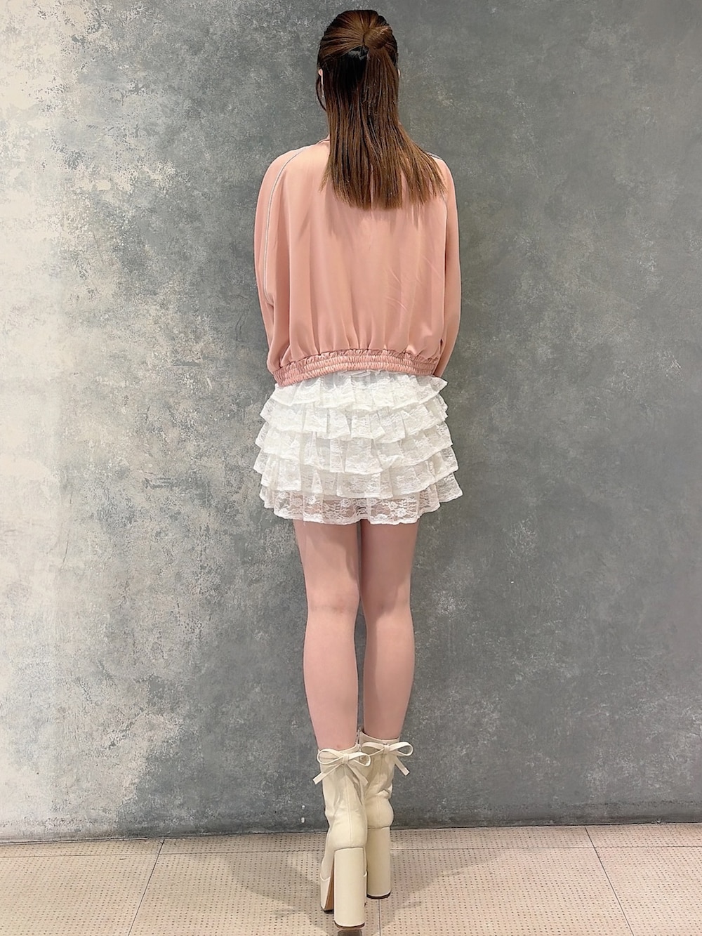 ピンク系のその他アウター、ホワイト系のスカート、ホワイト系のニット/セーターを着用したレディースの冬コーディネートの4枚目の写真