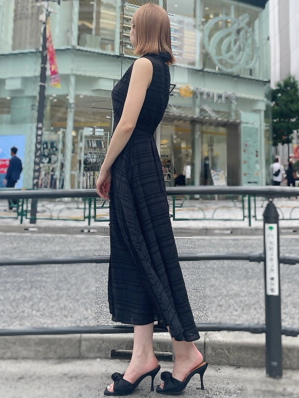 ブラック系のワンピース、ブラック系のサンダルを着用したレディースの夏コーディネートの3枚目の写真