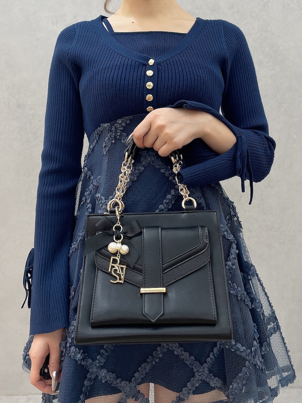 ブルー系のワンピース、ブラック系のハンドバッグ、ブラック系のブーツを着用したレディースの秋コーディネートの6枚目の写真