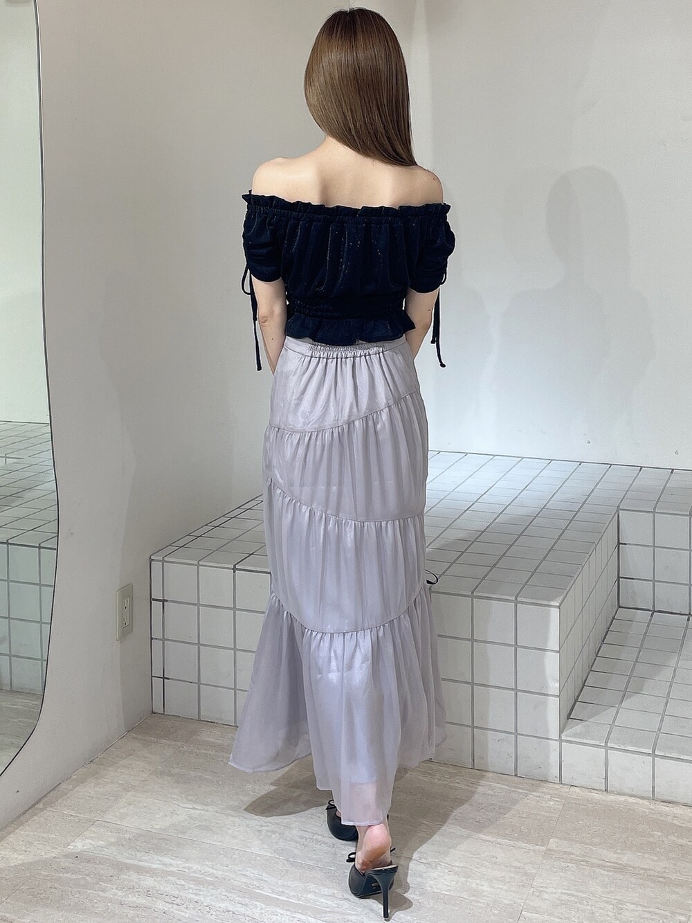 ブラック系のTシャツ/カットソー、ブルー系のスカート、ブラック系のパンプスを着用したレディースの夏コーディネートの3枚目の写真