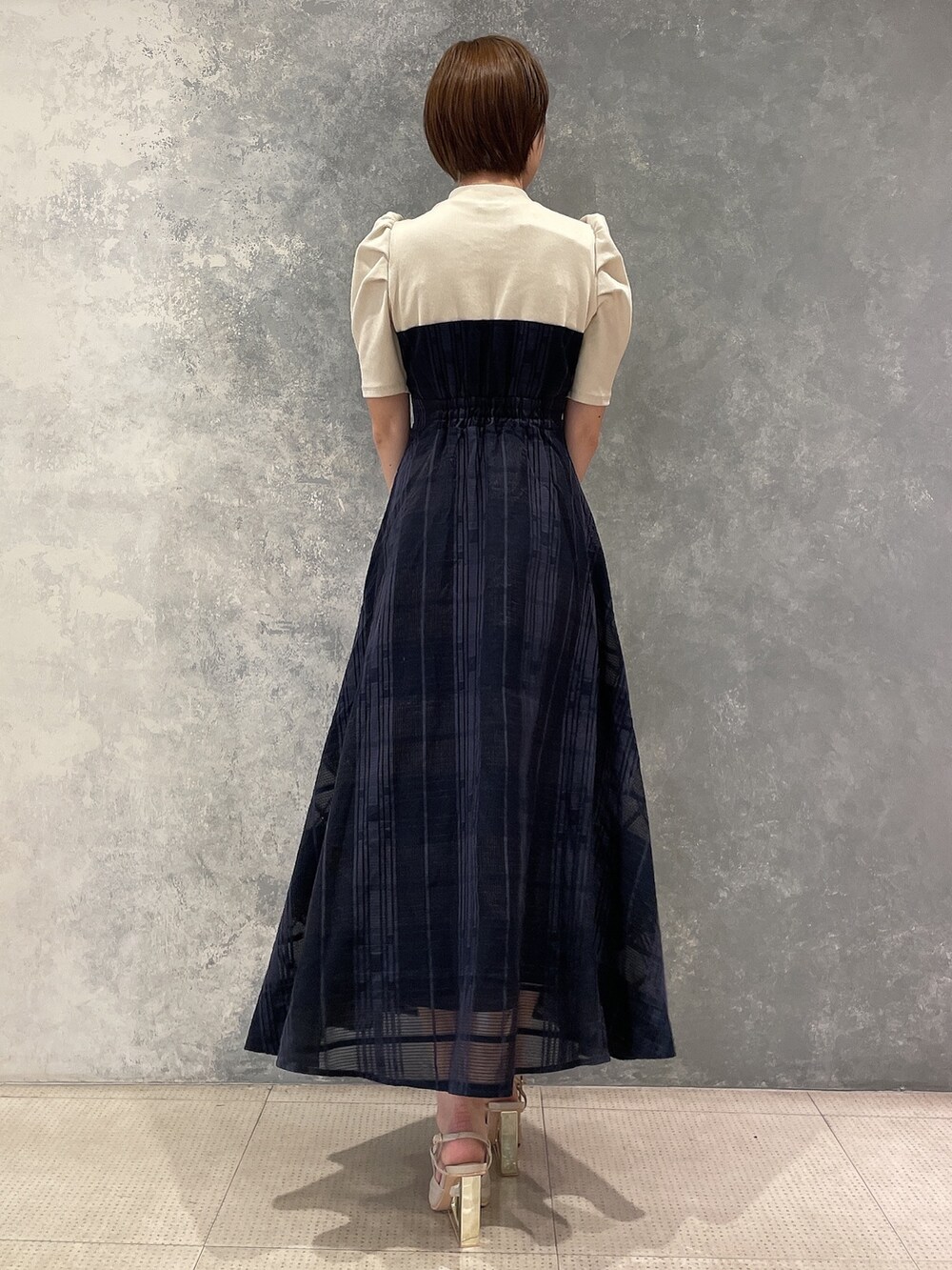 ホワイト系のライダースジャケット、ベージュ系のサンダル、ブルー系のワンピースを着用したレディースの夏コーディネートの7枚目の写真