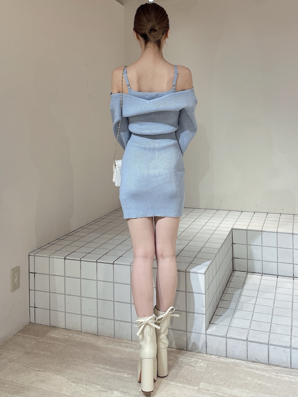 ブルー系のワンピース、ホワイト系のショルダーバッグ、ホワイト系のブーツを着用したレディースの冬コーディネートの4枚目の写真