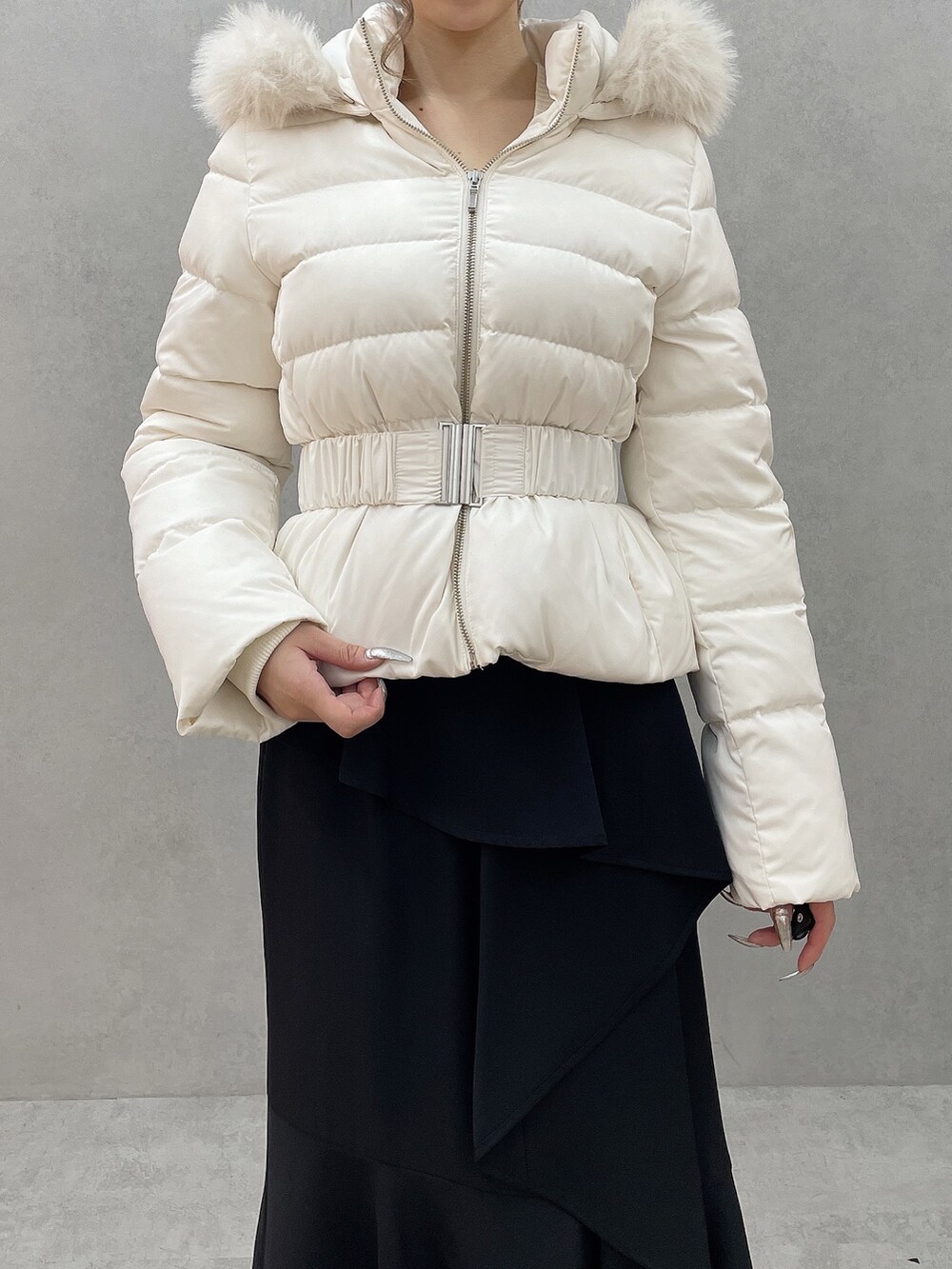 ホワイト系のダウンジャケット/コート、ホワイト系のニット/セーター、ブラック系のスカートを着用したレディースの秋コーディネートの7枚目の写真