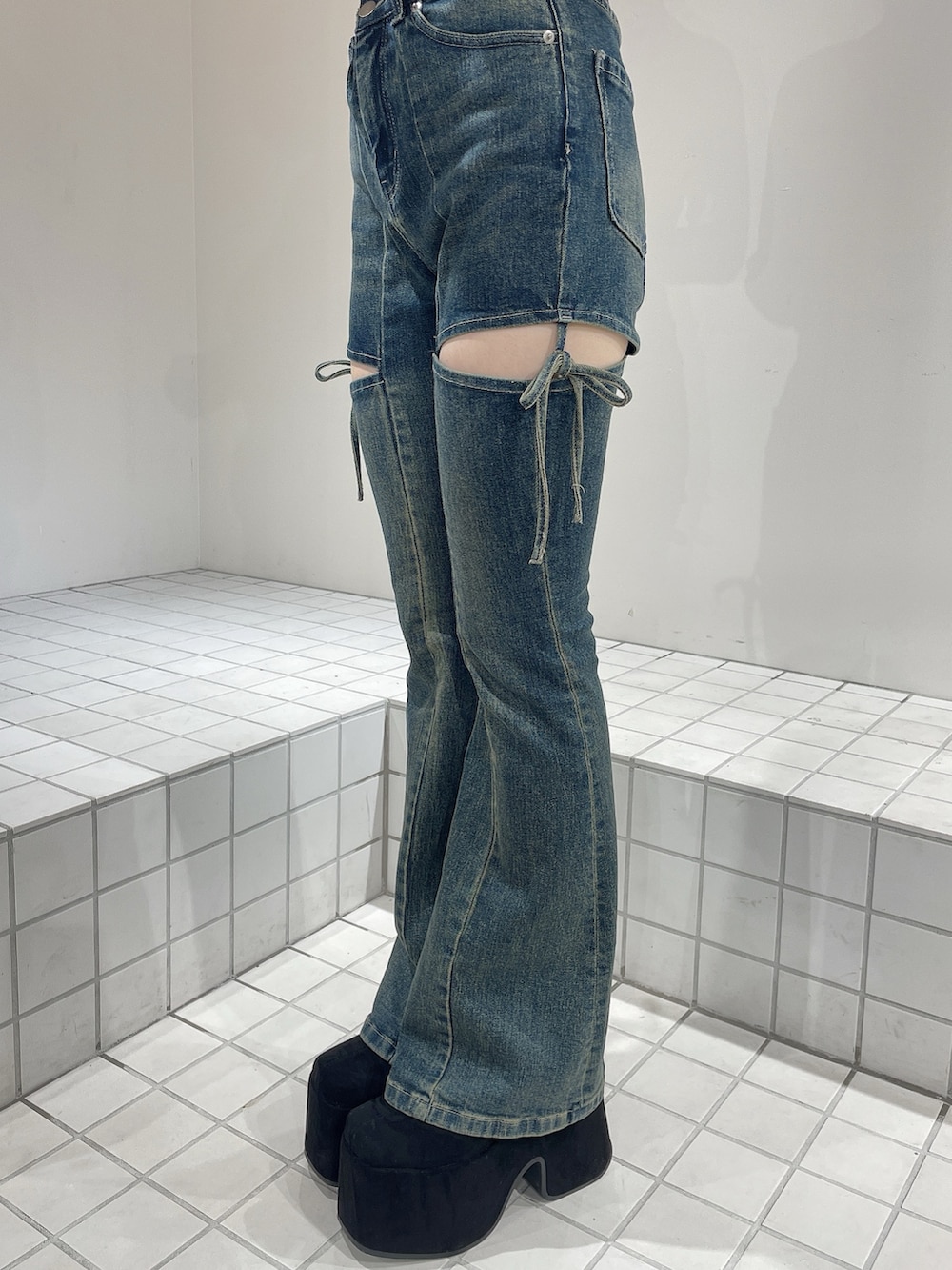 レッド系のニット/セーター、ブルー系のデニムパンツ、ブラック系のブーツを着用したレディースの秋コーディネートの8枚目の写真