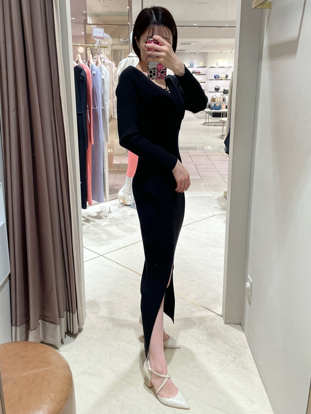 ブラック系のワンピース、ホワイト系のパンプスを着用したレディースの冬コーディネートの4枚目の写真