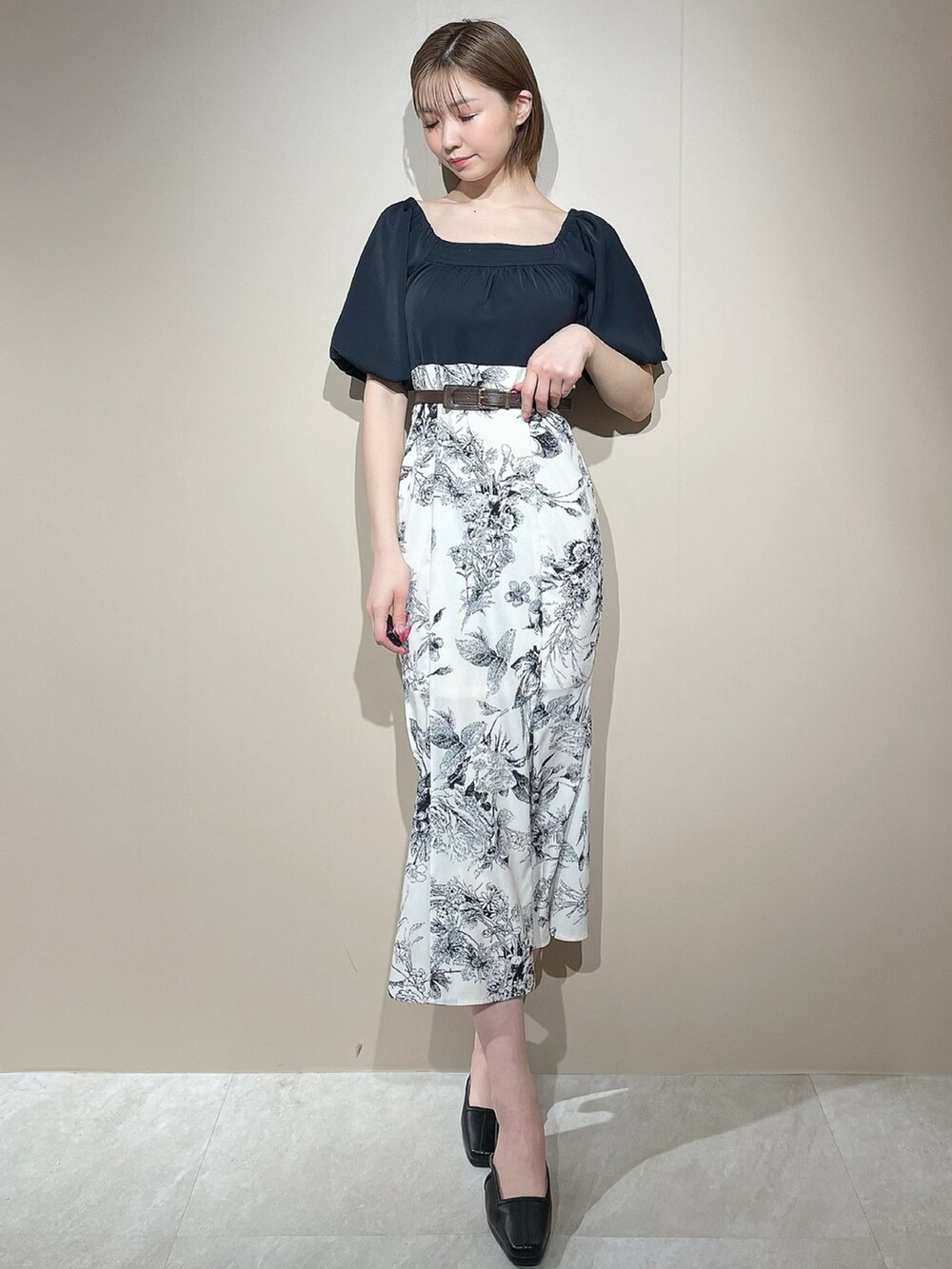 ブラック系のワンピース、ブラック系のパンプス、ブラウン系のベルトを着用したレディースの春コーディネートの4枚目の写真