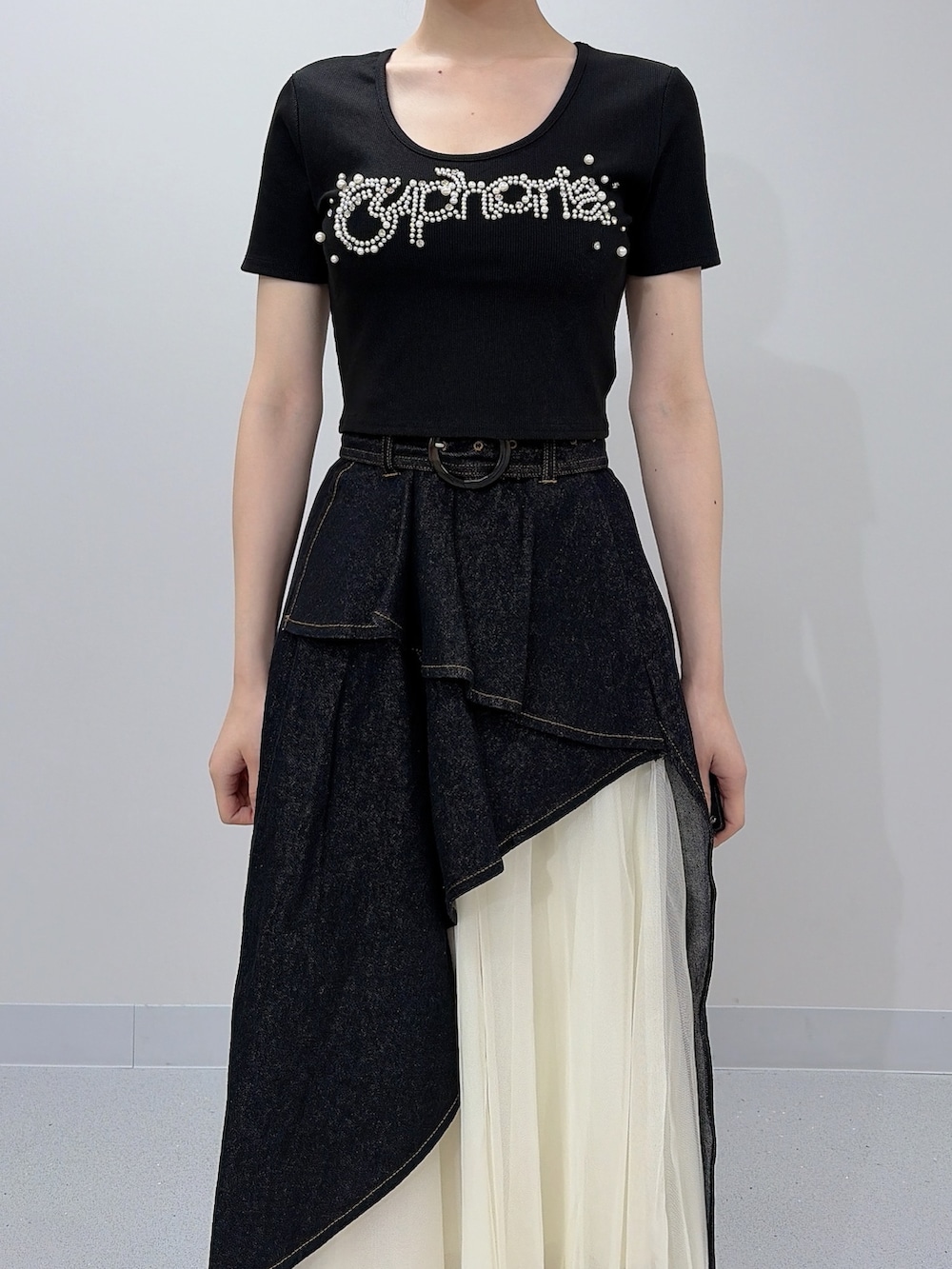 ブラック系のTシャツ/カットソー、ブラック系のスカート、ブラック系のサンダルを着用したレディースの夏コーディネートの6枚目の写真