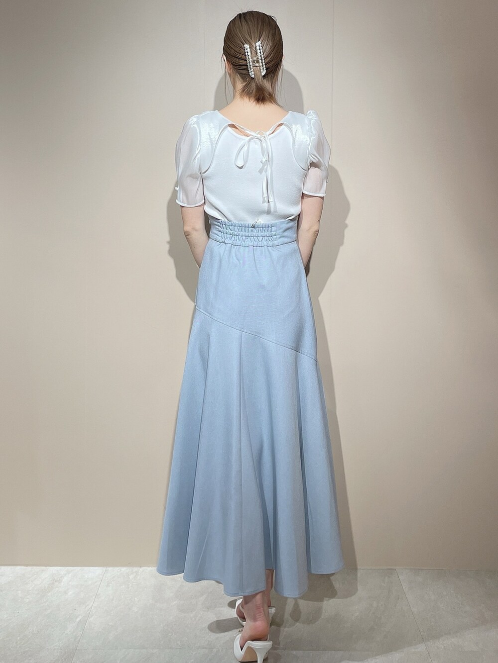 ホワイト系のニット/セーター、ブルー系のスカートを着用したレディースの春コーディネートの4枚目の写真