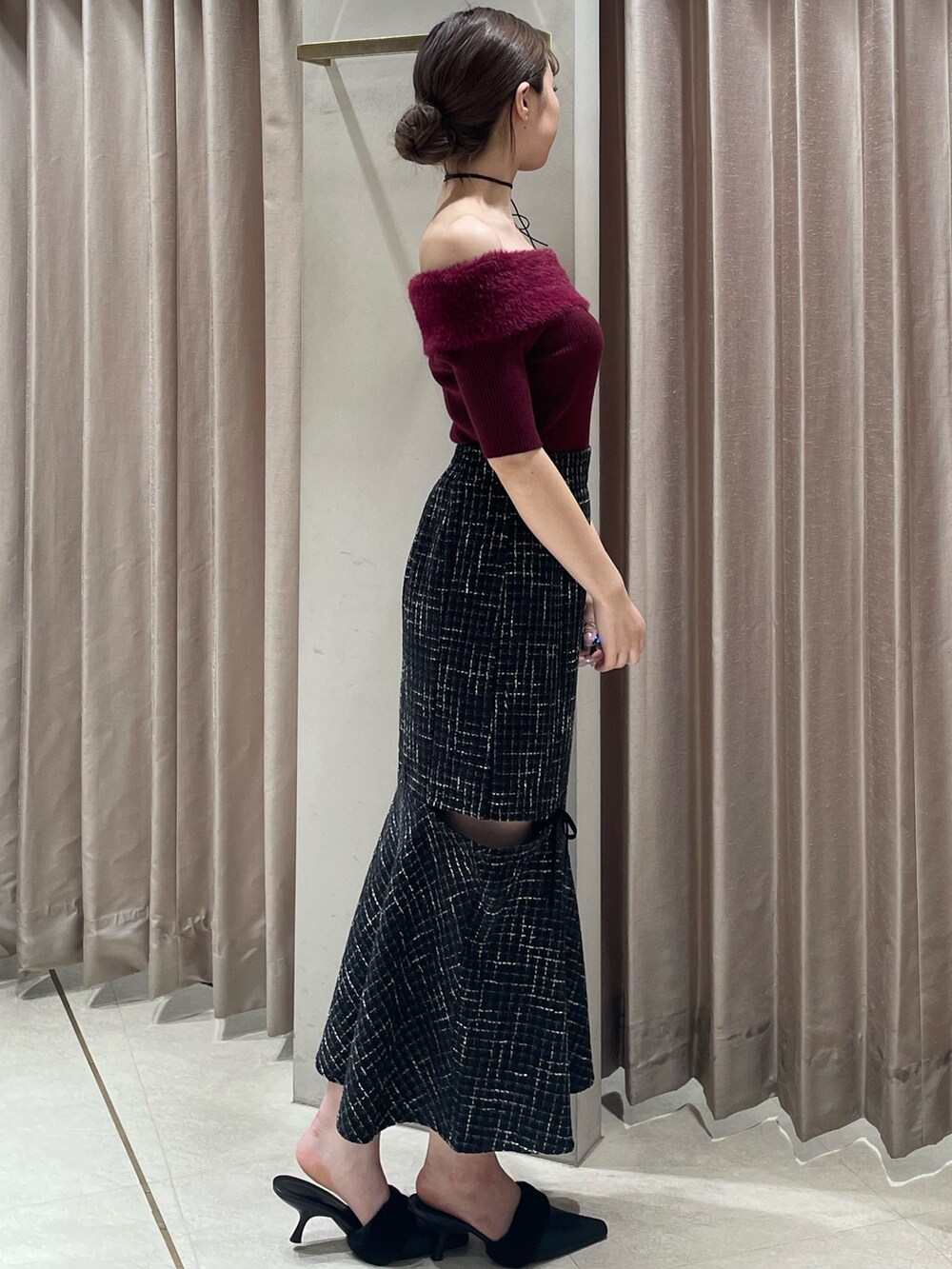 レッド系のニット/セーター、ブラック系のスカート、ブラック系のパンプスを着用したレディースの夏コーディネートの2枚目の写真