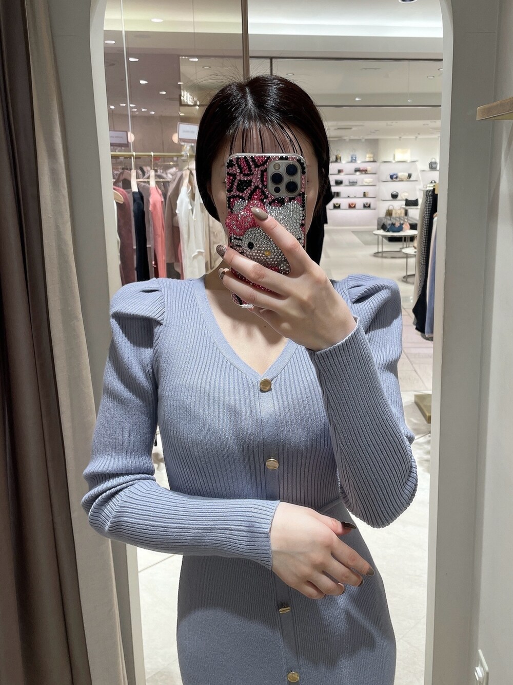ホワイト系のパンプス、ブルー系のワンピース、ホワイト系のライダースジャケットを着用したレディースの冬コーディネートの4枚目の写真