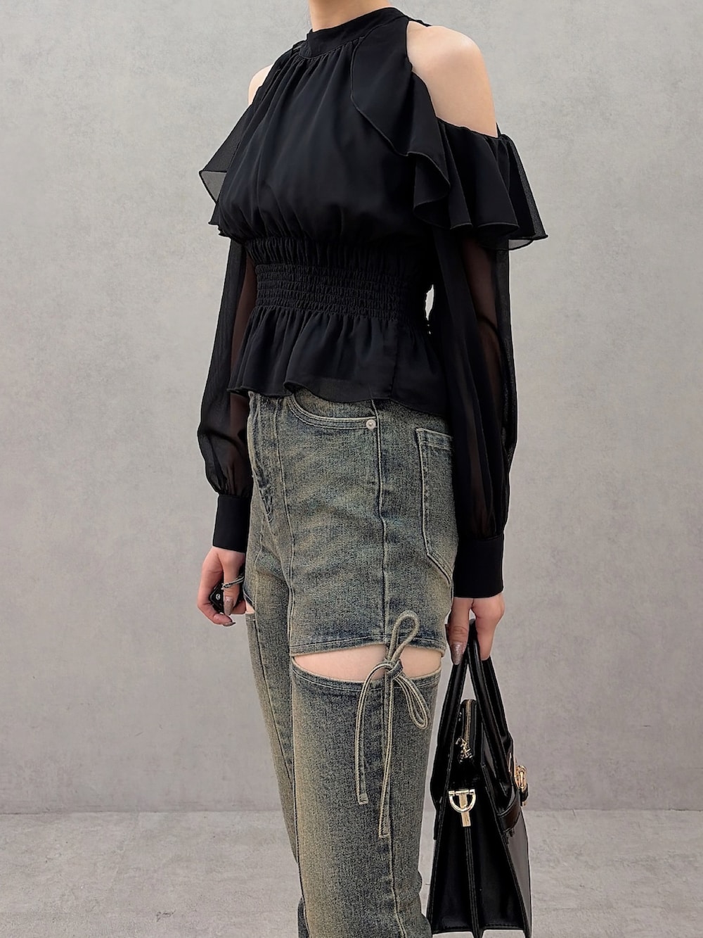 ブラック系のシャツ/ブラウス、ブルー系のデニムパンツ、ブラック系のハンドバッグを着用したレディースの秋コーディネートの7枚目の写真