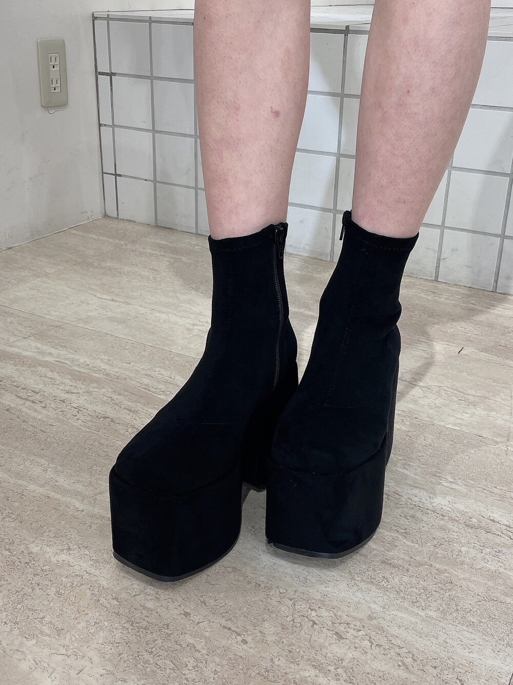 ブラック系のダウンジャケット/コート、ブラック系のワンピース、ブラック系のブーツを着用したレディースの秋コーディネートの8枚目の写真