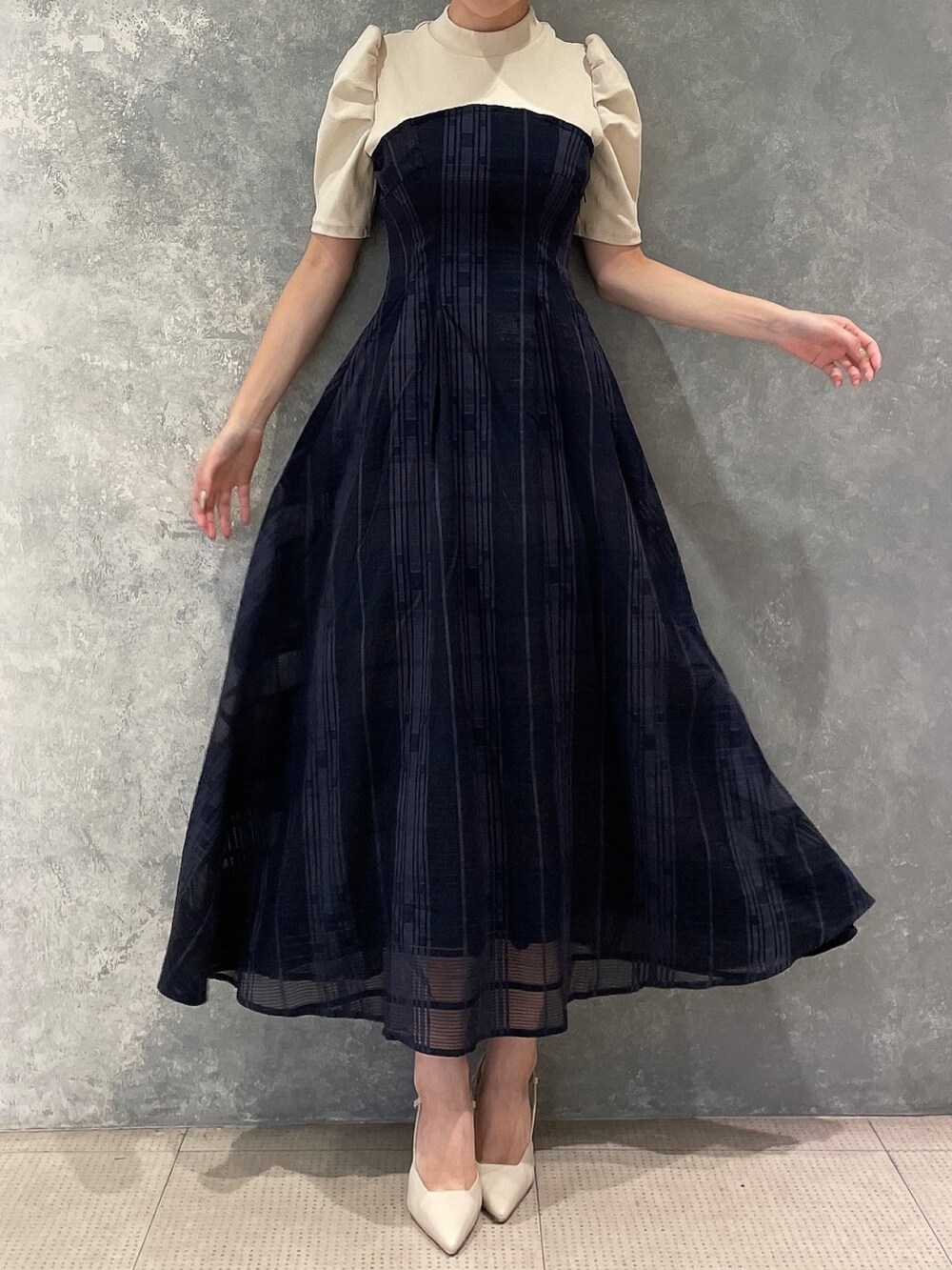 ホワイト系のライダースジャケット、ベージュ系のサンダル、ブルー系のワンピースを着用したレディースの夏コーディネートの4枚目の写真