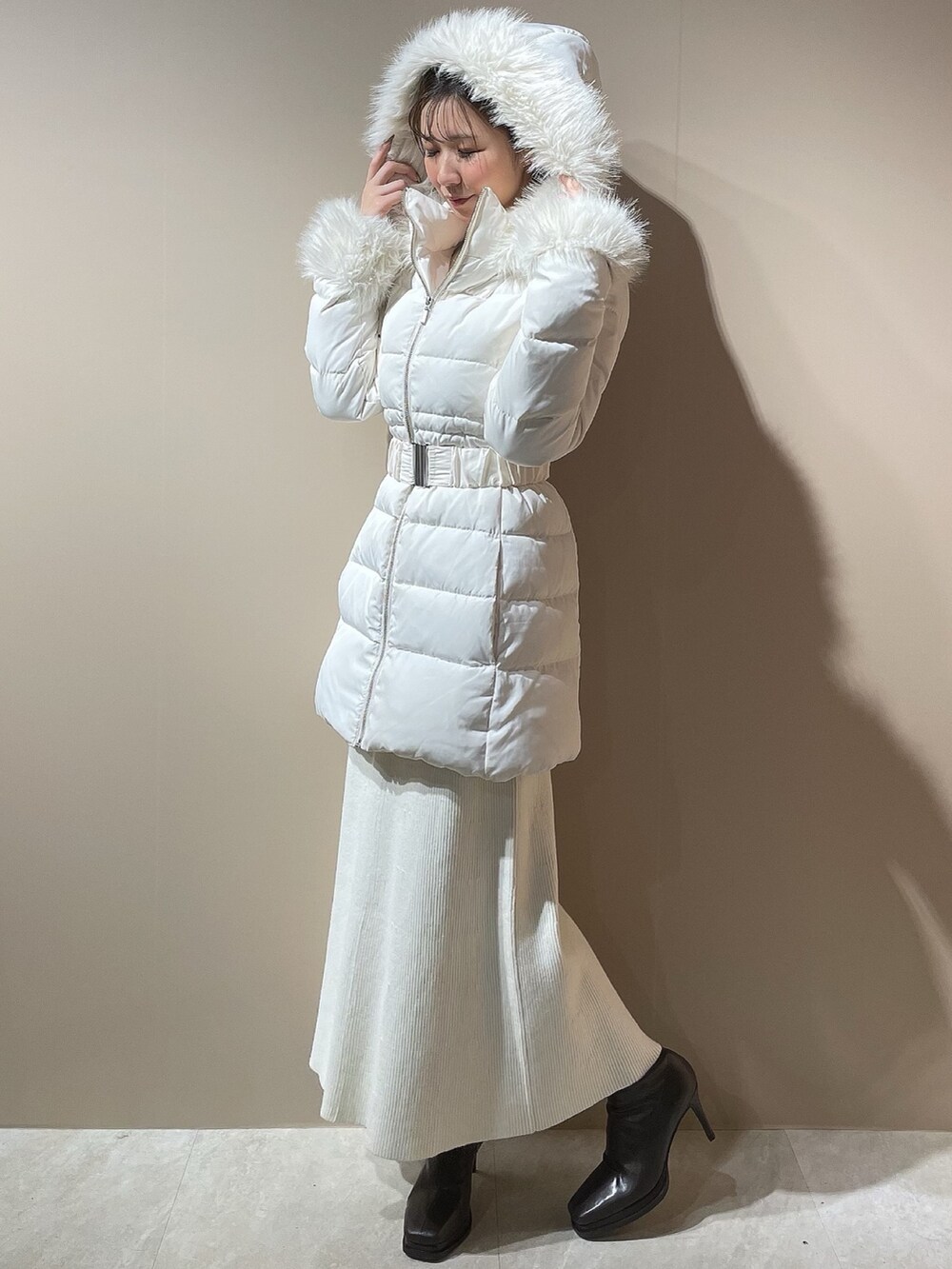 ホワイト系のダウンジャケット/コート、ホワイト系のワンピース、ブラウン系のブーツを着用したレディースの秋コーディネートの3枚目の写真