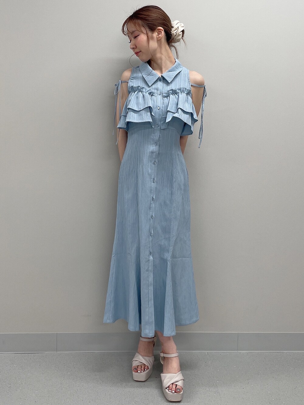 ブルー系のシャツワンピース、ベージュ系のサンダルを着用したレディースの春コーディネートの2枚目の写真