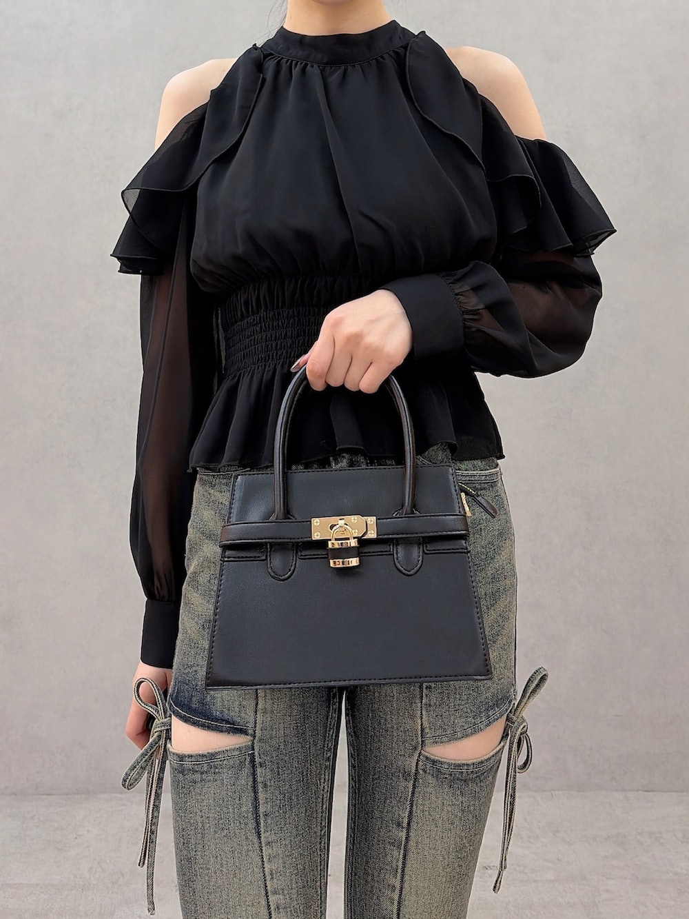 ブラック系のシャツ/ブラウス、ブルー系のデニムパンツ、ブラック系のハンドバッグを着用したレディースの秋コーディネートの8枚目の写真