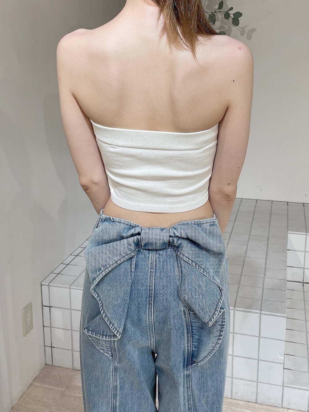 ホワイト系のサンダル、ブルー系のデニムパンツ、ホワイト系のキャミソールを着用したレディースの夏コーディネートの6枚目の写真