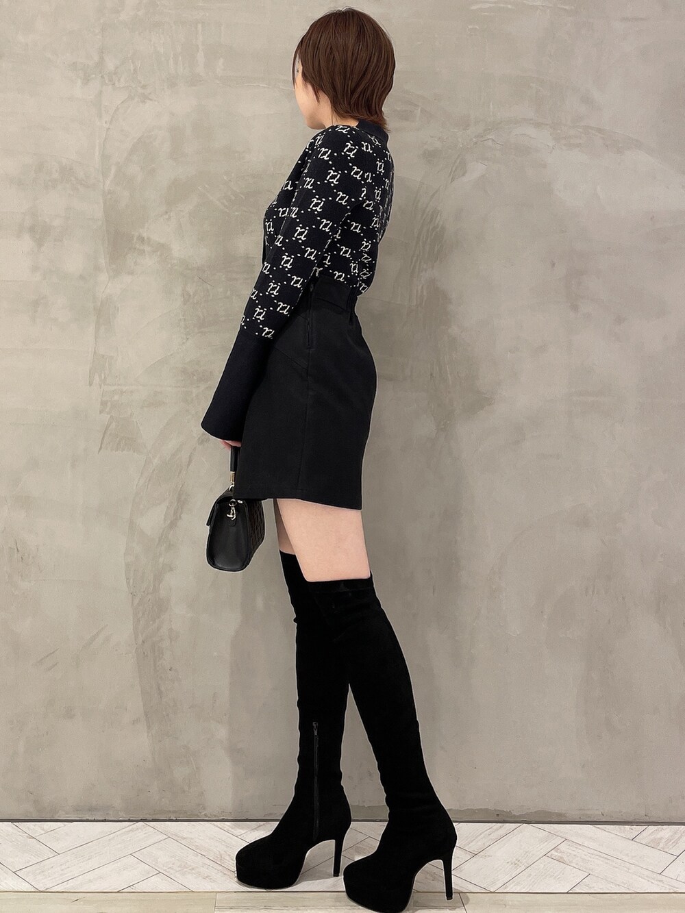 ブラック系のブーツ、ブラック系のハンドバッグ、ブラック系のその他パンツを着用したレディースの冬コーディネートの2枚目の写真