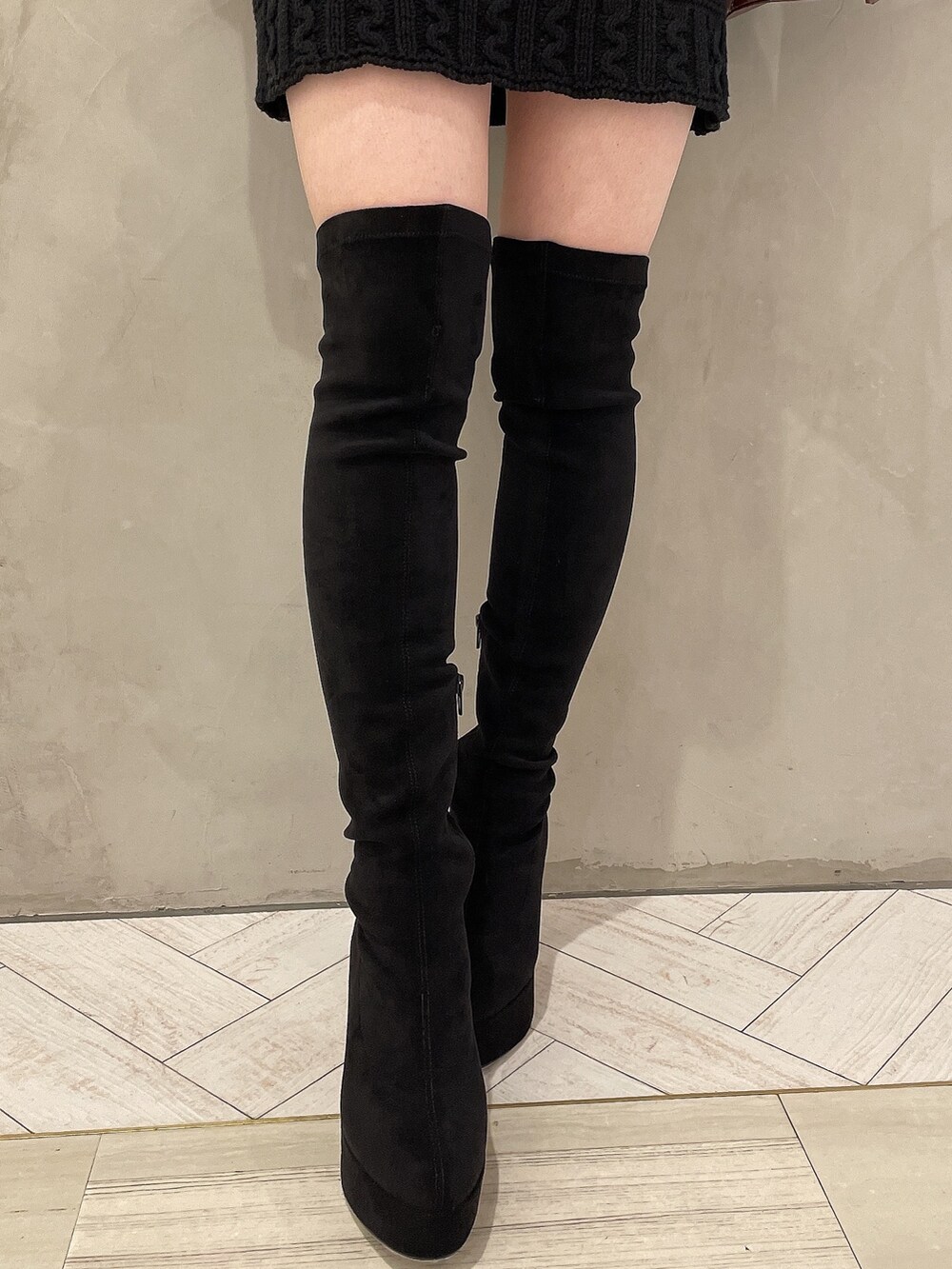 ブラウン系のハンドバッグ、ブラック系のブーツ、ブラック系のニット/セーターを着用したレディースの秋コーディネートの9枚目の写真