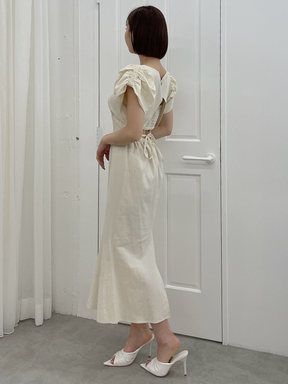 ホワイト系のワンピース、ホワイト系のサンダルを着用したレディースの春コーディネートの4枚目の写真