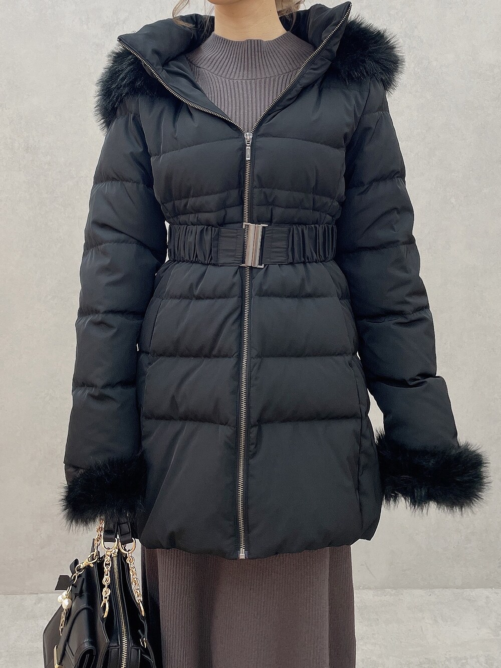 グレー系のワンピース、ブラック系のハンドバッグ、ブラック系のブーツを着用したレディースの秋コーディネートの6枚目の写真