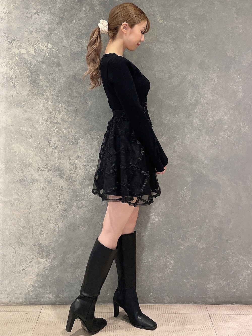 グレー系のその他アウター、ブラック系のワンピース、ブラック系のブーツを着用したレディースの秋コーディネートの5枚目の写真