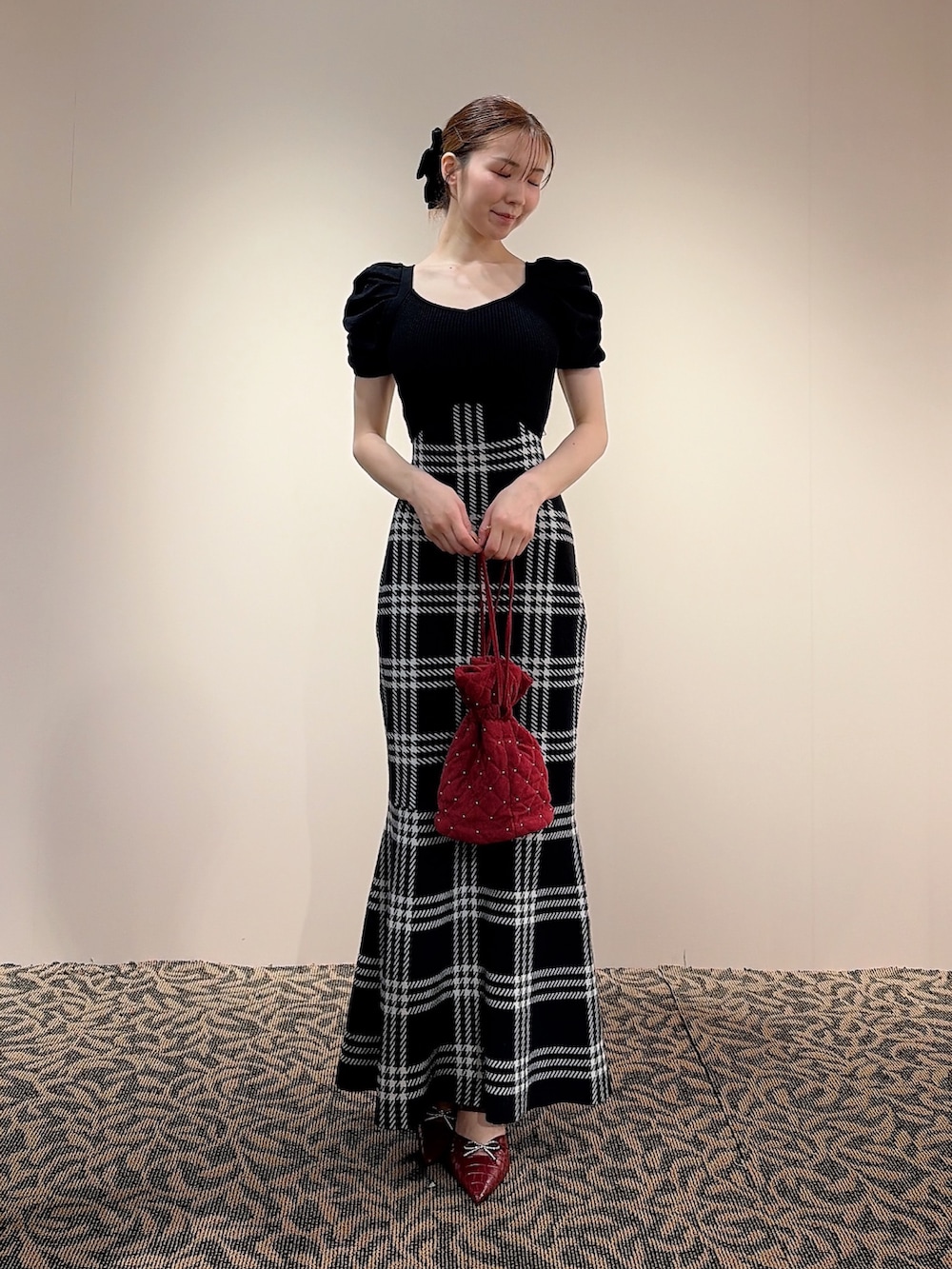 ブラック系のワンピース、レッド系のハンドバッグ、ブラック系のバレッタ/ヘアクリップを着用したレディースの夏コーディネートの2枚目の写真